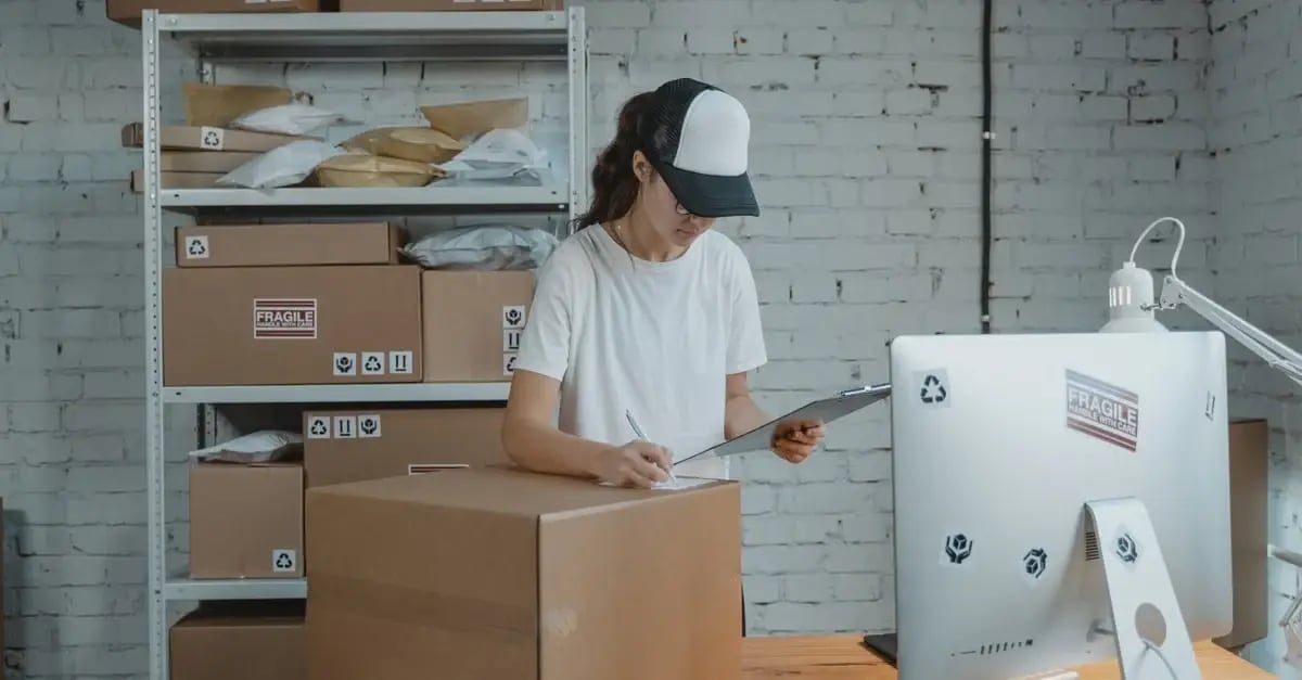 Worker preparing cardboard boxes for shipping, demonstrating efficient fulfillment with smart Amazon PPC strategy planning.